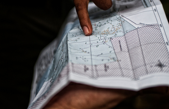 Center for International Forestry Reseach (CIFOR) scientists examining maps of Felicitas Ramirez Surco's Brazil nut concession, near Puerto Maldonado, Madre de Dios, Peru. Photo by Marco Simola for CIFOR)