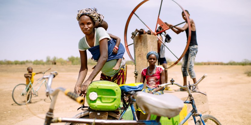 Barry Aliman, 24 years old, bicycles with her baby to fetch water for her family, Sorobouly village near Boromo, Burkina Faso. Ollivier Girard/CIFOR
